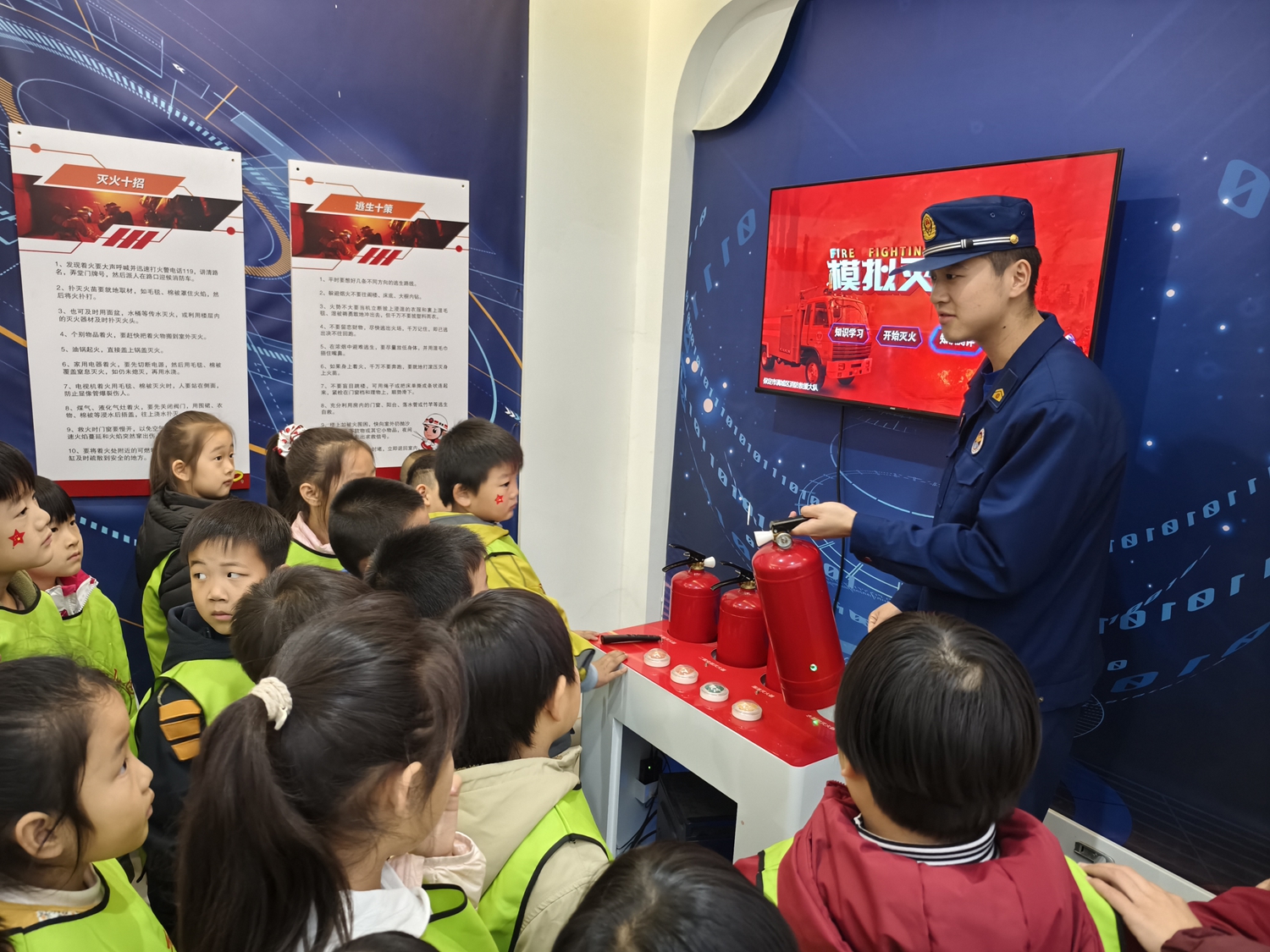 图片默认标题_fororder_工作人员向幼儿介绍灭火器使用方法 摄影 张芳