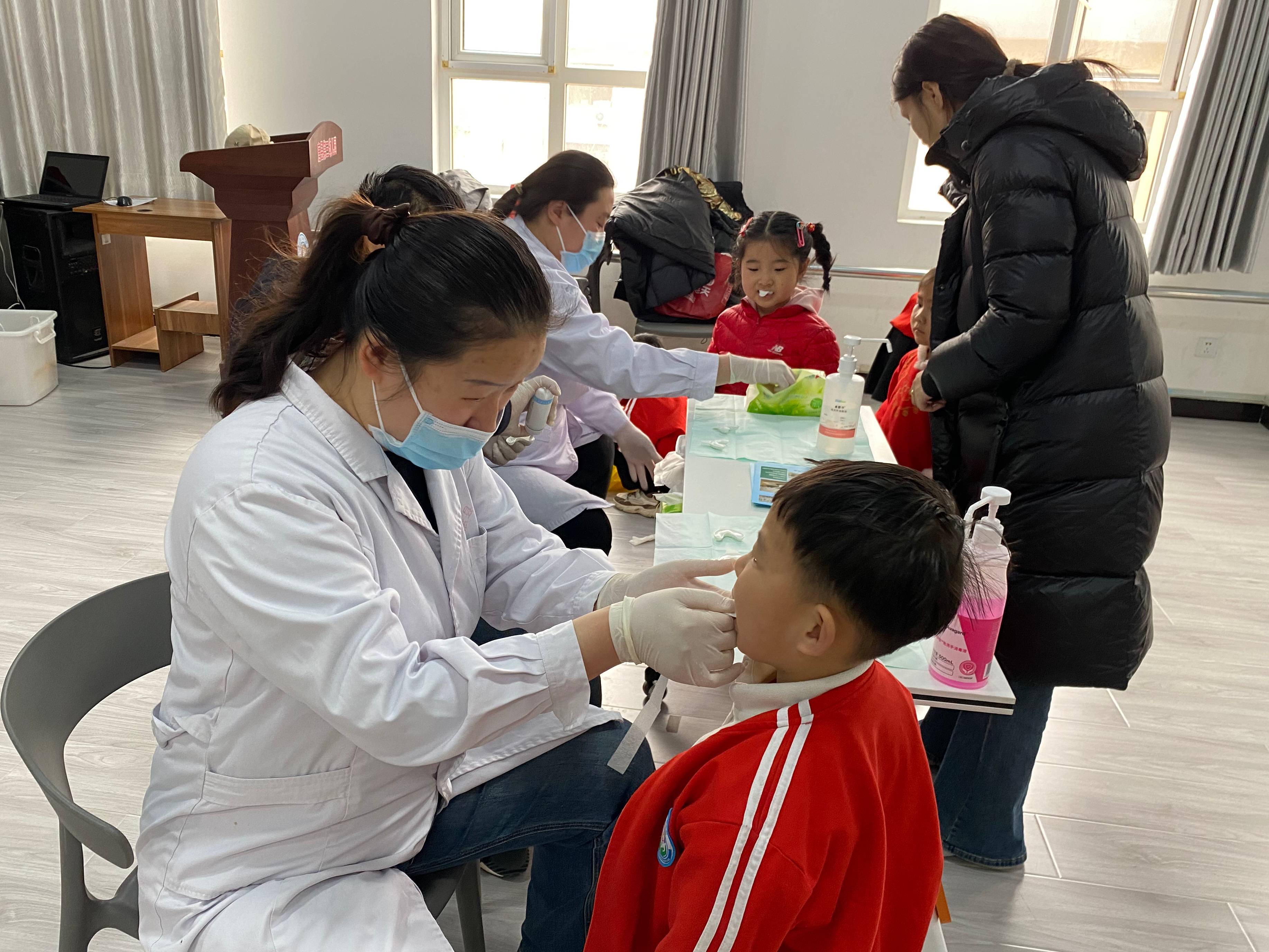 河北唐县:“护牙小卫士 涂氟助成长”——第三幼儿园开展涂氟防龋活动_fororder_医护人员为小朋友检查