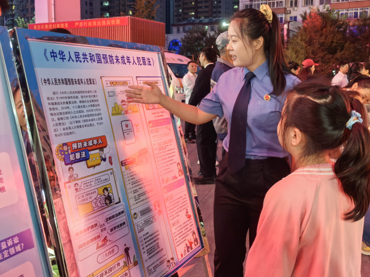 寓教于乐!遵化国庆法治宣传活动吸引市民踊跃参与_fororder_图为工作人员普及法律知识