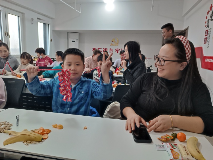 遵化市华明路街道:情暖社区迎元旦 邻里同心谱新篇_fororder_小朋友正在展示他做的“创意鞭炮”。张丽杰摄