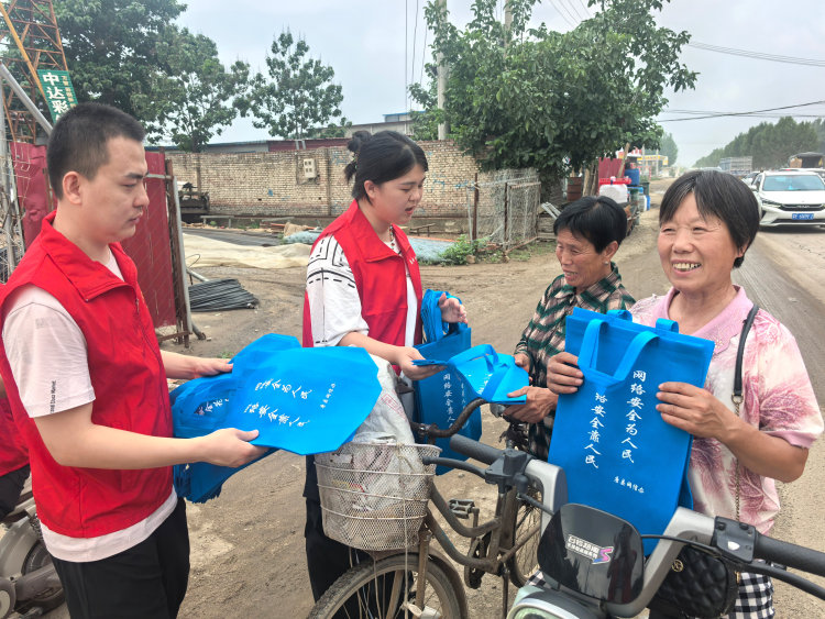河北唐县:网络安全进乡村 数字素养促提升_fororder_在唐县南店头村,志愿者讲解网络安全知识并发放宣传手袋
