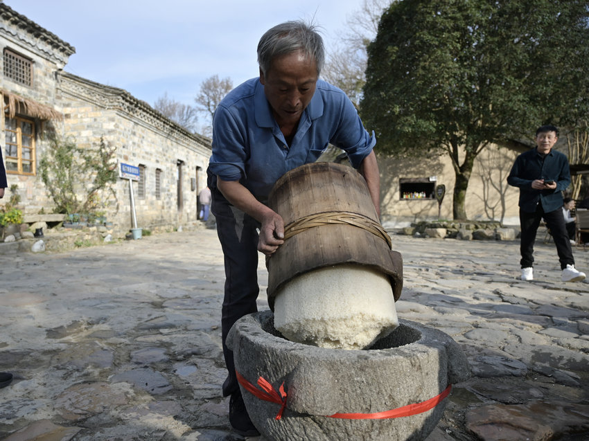 信阳市新县:古村糍粑香 民俗韵味长_fororder_将蒸好的糯米倒进石臼中(焦汉平 摄)