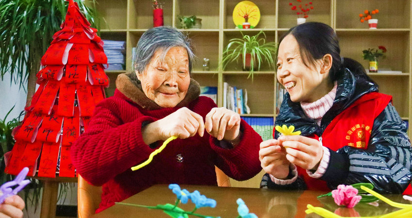 南阳市西峡县:家门口养老 托起幸福晚年_fororder_关巷社区工作人员陪老人一起做益智手工.JPG