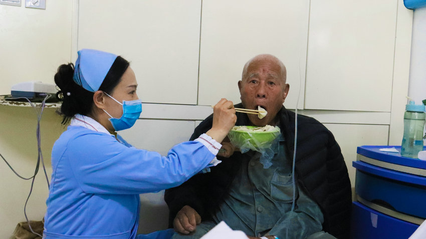 暖心冬至 “饺”聚温情 南阳市中医院举办冬至包饺子比赛_fororder_护士喂病人吃饺子.JPG