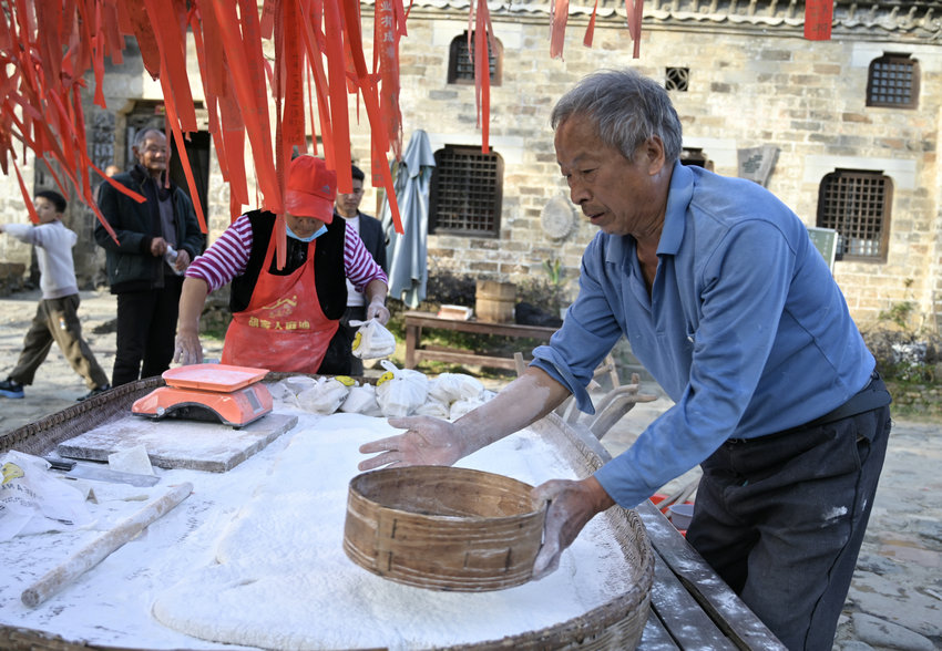 信阳市新县:古村糍粑香 民俗韵味长_fororder_撒上糯米面儿(焦汉平 摄)