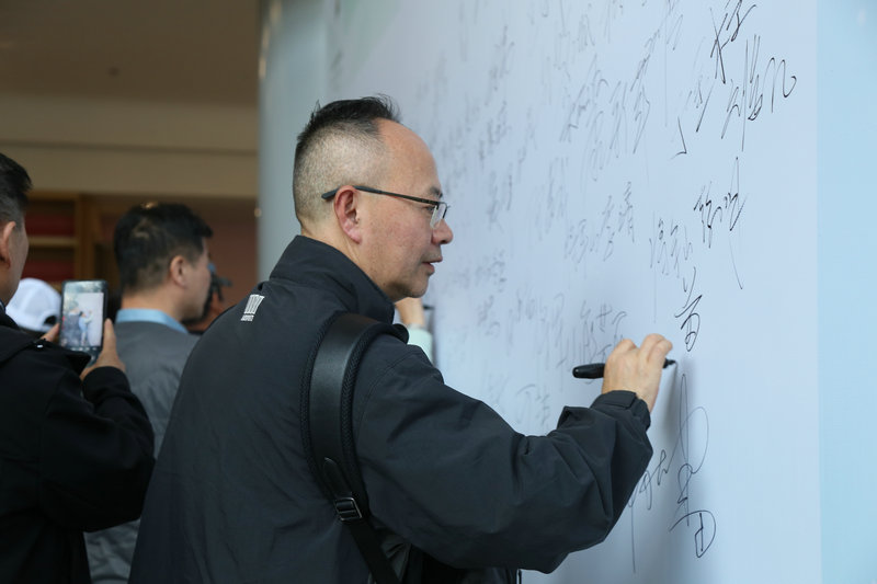 信阳市新县举办文旅推介活动 向全国游客发出冬季邀约_fororder_与会嘉宾在签名墙上签名(王丽君 摄)