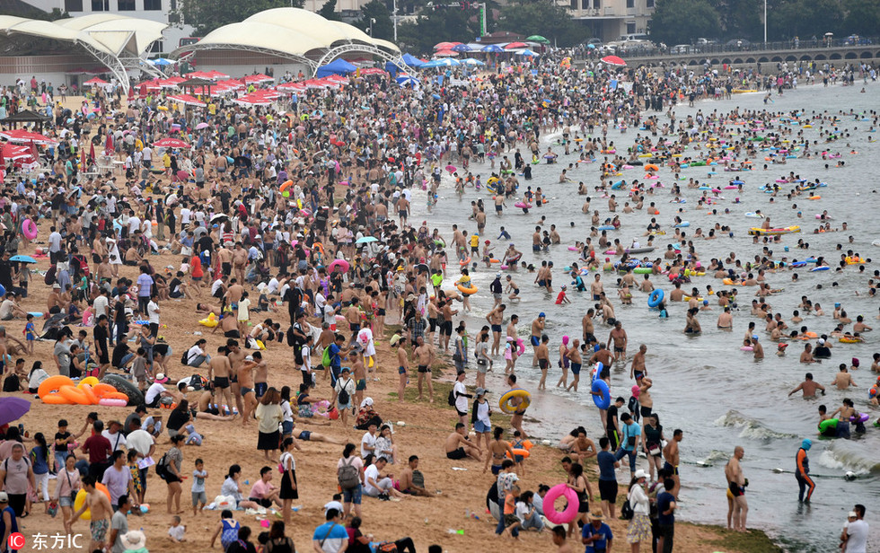 盛夏高温酷暑难耐 青岛浴场游客“下饺子”避暑