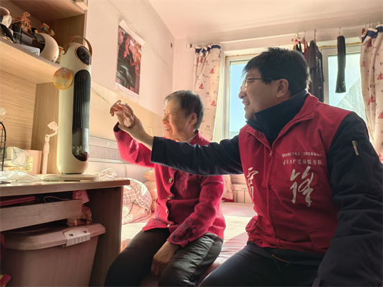 国网沈阳供电公司：关爱残障人士 63载初心护光明_fororder_郭家爱心雷锋共产党员服务队为盲人李凤珍阿姨送去智能电暖器，指导阿姨使用该设备。