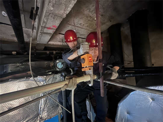 方大集团中兴商业暖通科：为消费者筑起“温暖屏障”_fororder_在狭小的棚顶里，中兴商业暖通科员工在聚精会神地检修设备-2 摄影：徐晨