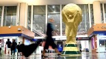 中国元素深度融入2026年美加墨世界杯_fororder_6月9日，在墨西哥首都墨西哥城的贝尼托·华雷斯国际机场的候机大厅，旅客从“大力神杯”模型旁走过