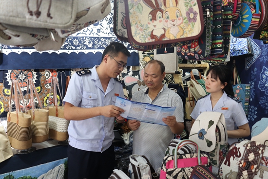贵州安顺税务：税收赋能 擦亮“21℃的城市”IP品牌_fororder_安顺市镇宁县税务局干部走进景区纪念品店为纳税人介绍最新税费优惠政策（拍摄：舒开培）