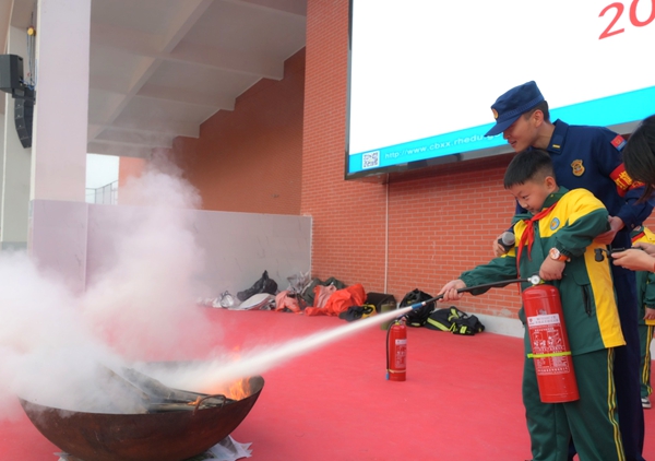 贵州仁怀：以宣促防 织密“校园消防网”_fororder_在消防员的帮助下，学生使用灭火器灭火