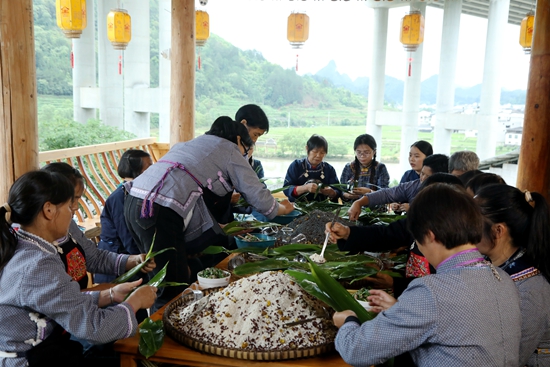 贵州荔波：粽似飞鸟衔福至 浓情粽香祈安康_fororder_布依族妇女聚在一起包粽子、唱山歌、祈安康。（戴友维摄）.JPG