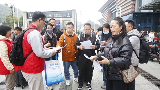 贵州长顺组织免费高铁专列护送务工人员返岗复工_fororder_工作人员发放相关资料.JPG