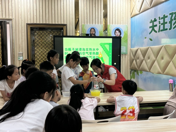 广西兴业：多彩文明实践 护航孩子快乐成长_fororder_小朋友在志愿者的协助下进行科学小实验