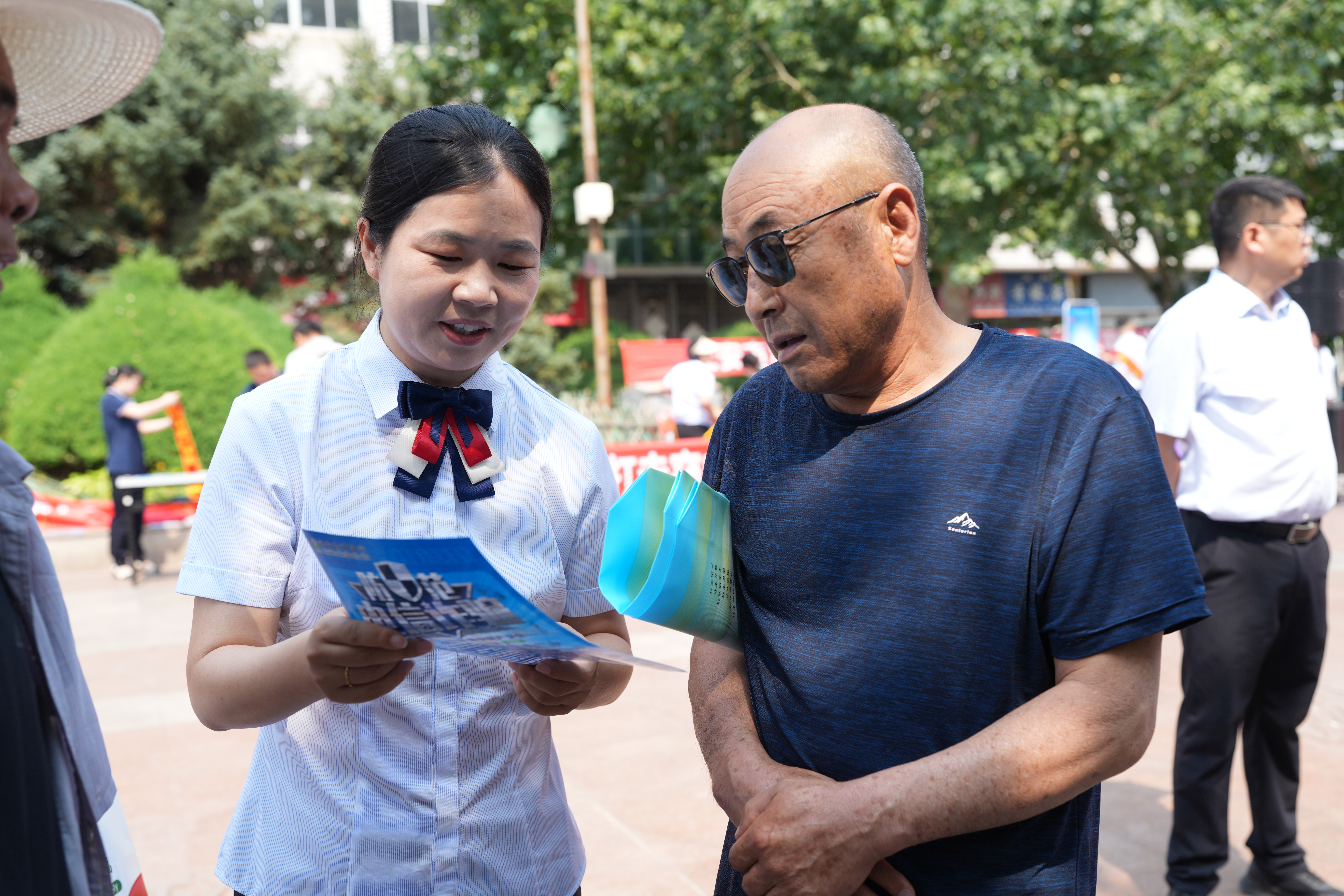 河北省迁安市开展防范非法金融活动宣传月集中宣传活动_fororder_6月13日上午，迁安市农商银行工作人员正在向市民讲解防范非法金融活动知识。张泽慧摄