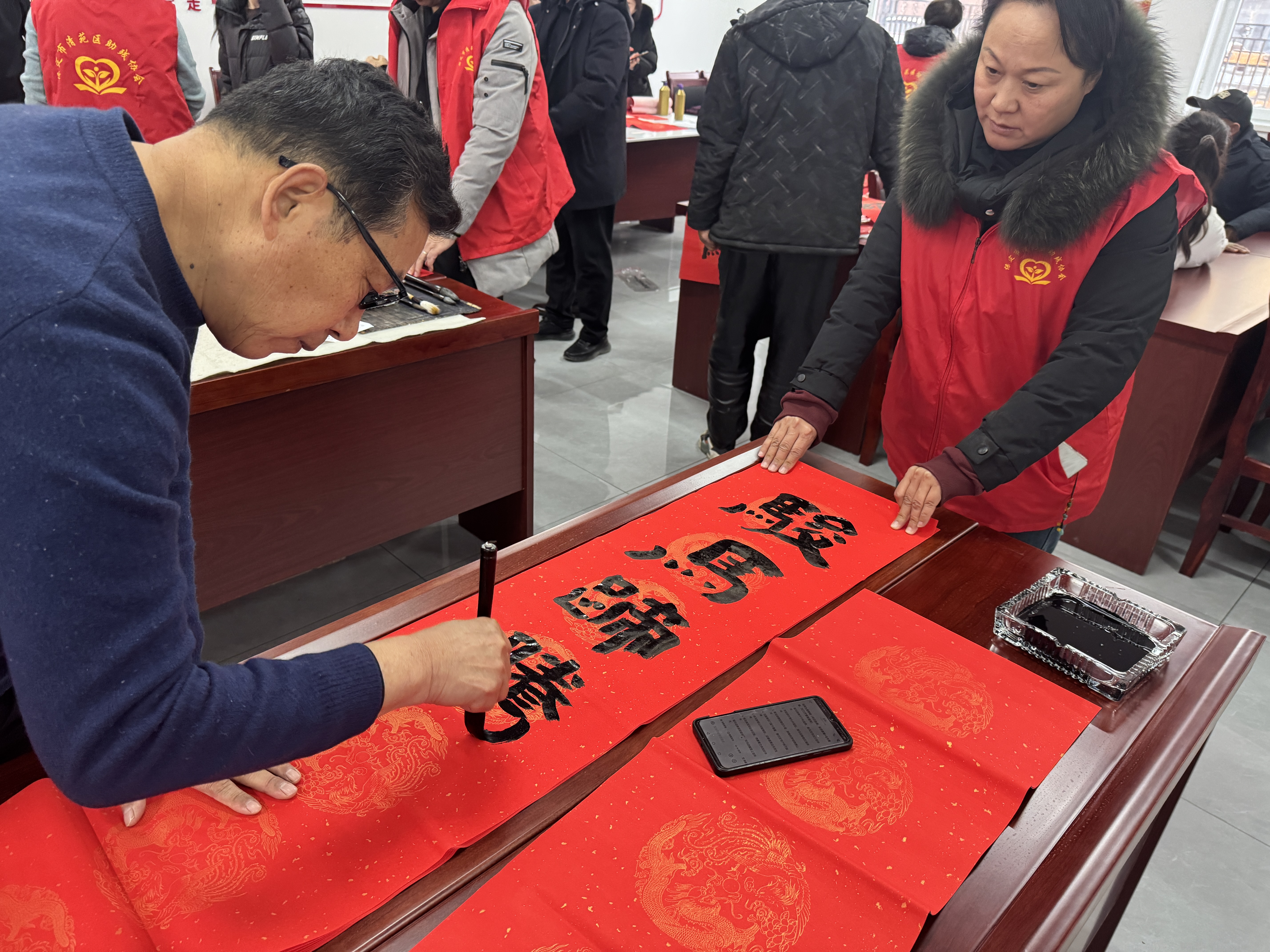 图片默认标题_fororder_清苑区“万福迎春公益送福进基层”活动志愿者挥毫泼墨。摄影 王俊