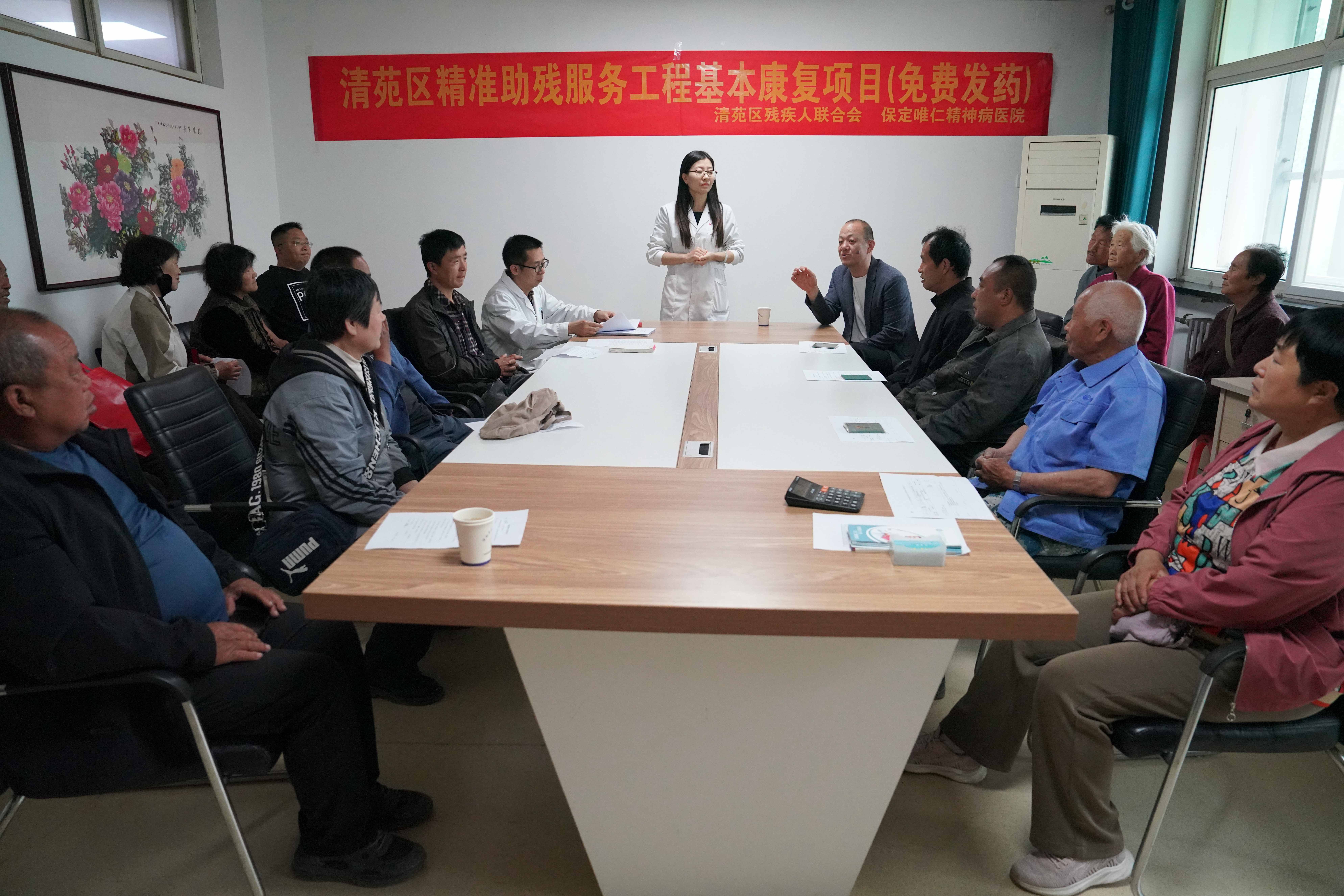 保定清苑：精准助残 免费发药暖民心_fororder_清苑区残联工作人员为有服药需求的精神障碍患者家属讲解精准助残服务工程基本康复项目免费发药政策。摄影 王磊