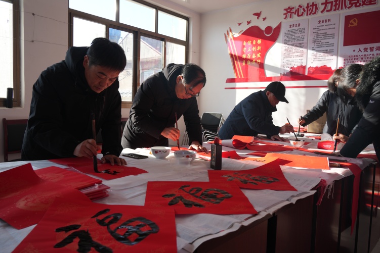 图片默认标题_fororder_图为文艺工作者为残疾、困难群众书写对联福字。遵化市残联供图