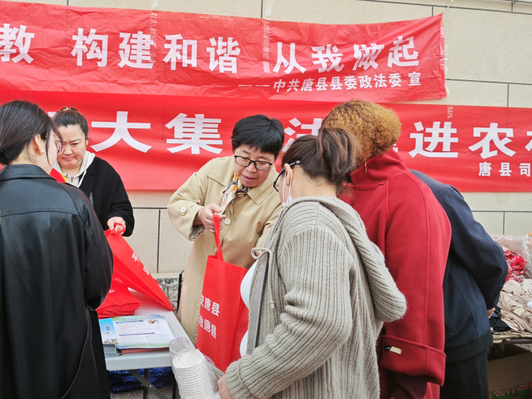 河北唐县：普法“赶庙会” 法治入人心_fororder_宣传人员为群众介绍普法“菜篮子”资料