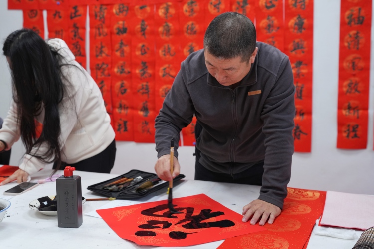 河北迁安：清风润佳节 翰墨书廉心_fororder_1月28日，书法爱好者正在写春联。张泽慧摄