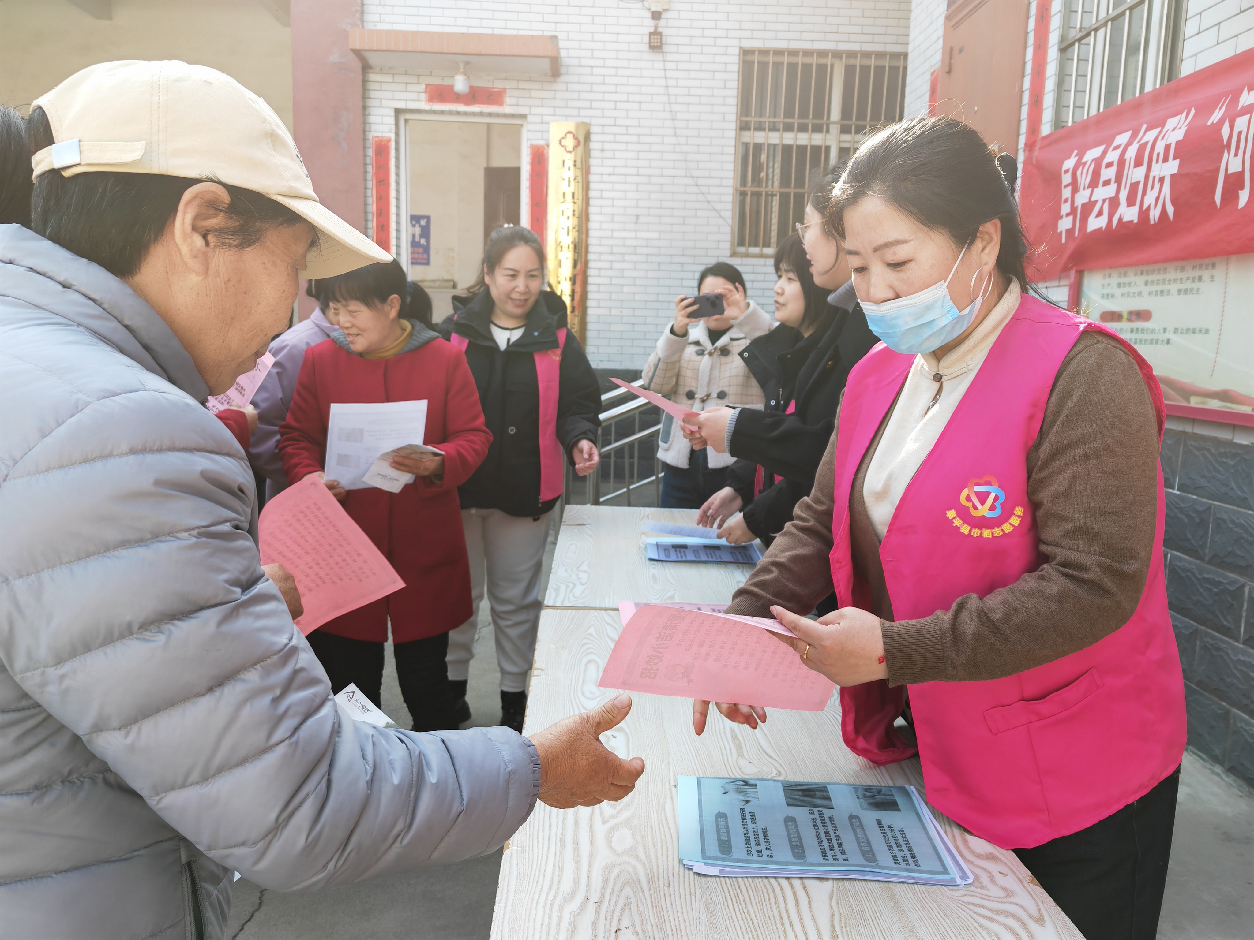 保定阜平：巾帼家政进社区 赋能妇女新生活_fororder_活动现场发放宣传材料。王赟摄