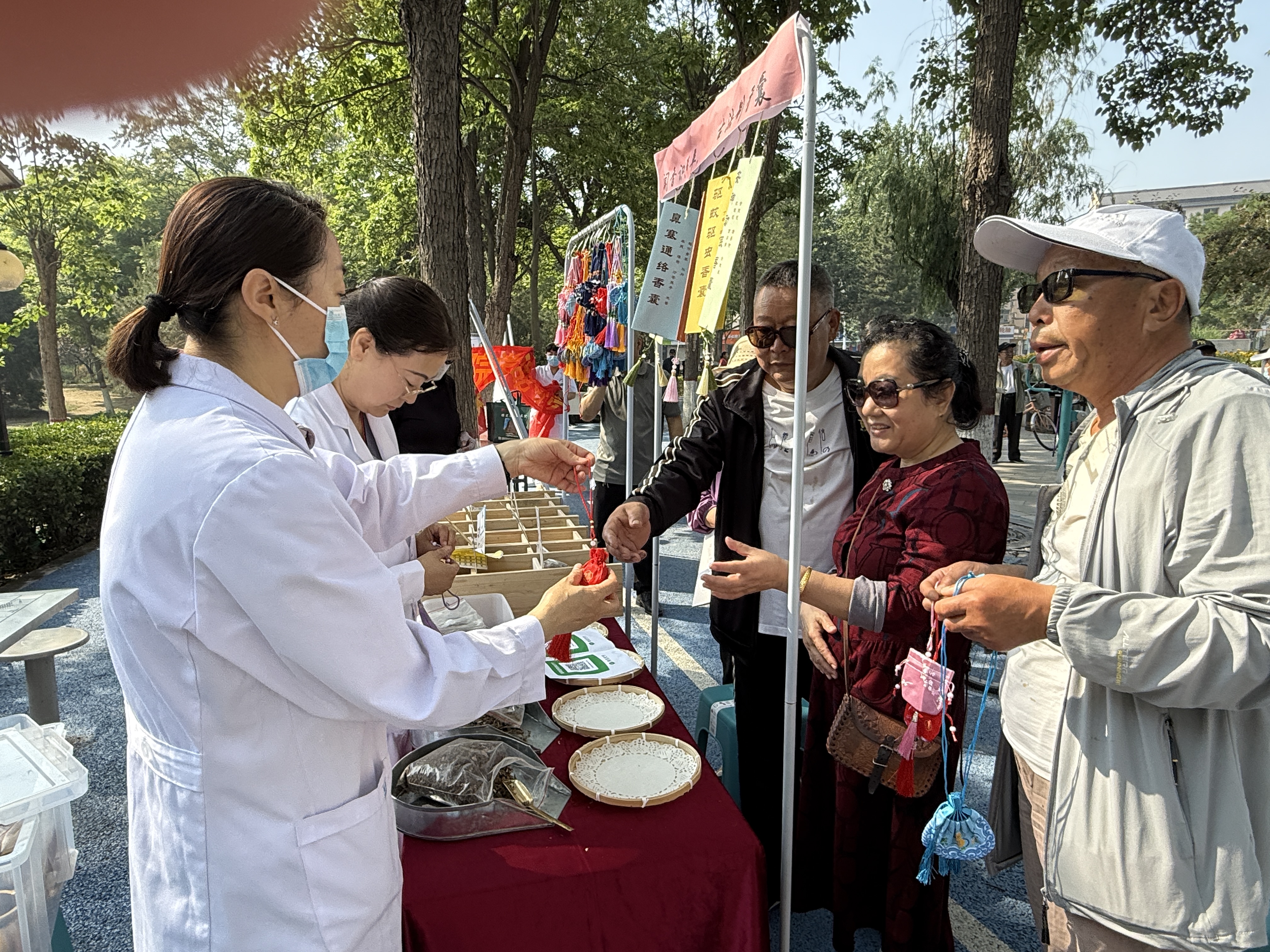 保定市莲池区：传承千年智慧 守护群众健康_fororder_图片四：工作人员为市民发放中药香囊。（李岩摄）