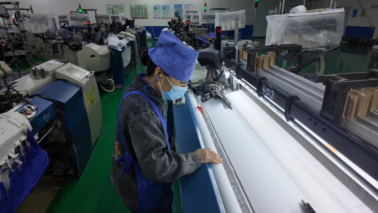 【新春走基层】保定莲池区：企业复工复产忙 全力冲刺“开门红”_fororder_图片四：保定三源纺织科技有限公司织造车间内，职工正在巡视织机，进行布面检查。（李凤苗摄）.JPG
