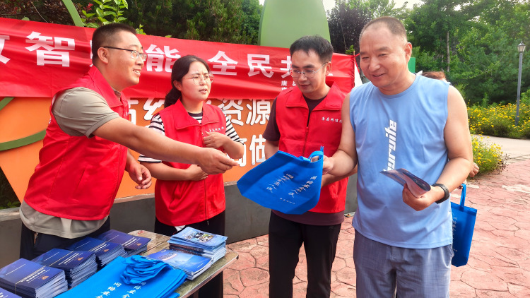 河北唐县：开展“数智赋能 全民共享”主题宣传进公园活动_fororder_工作人员发放宣传资料和宣传手袋