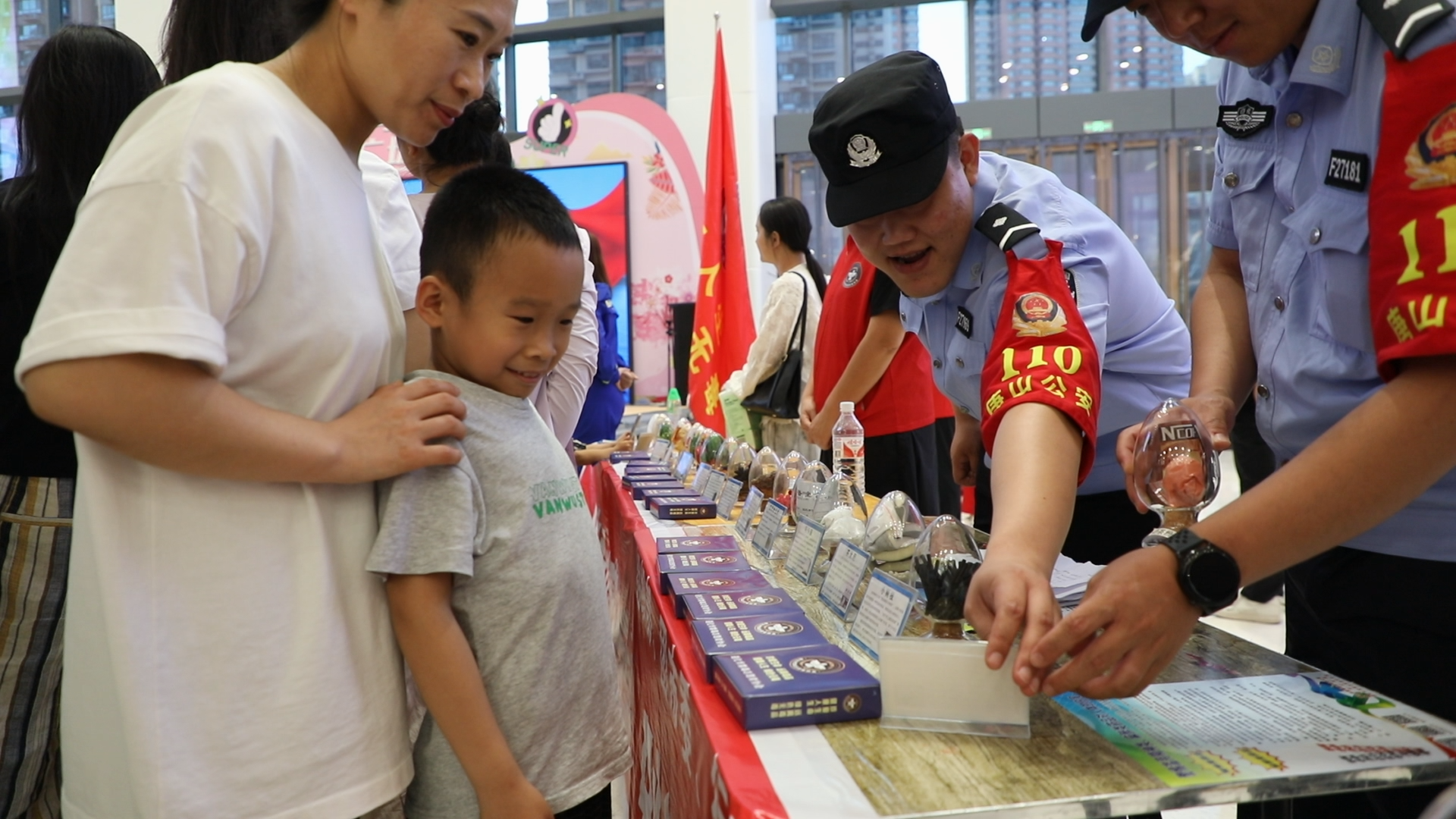 遵化市举办“禁毒月”大型禁毒文化展演活动_fororder_民警向参加活动的小朋友讲解毒品的种类。曹建林 摄