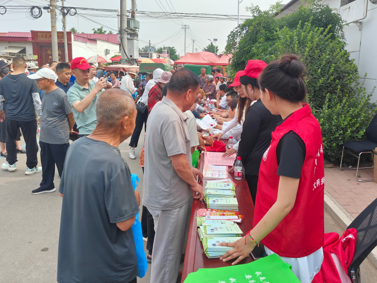 河北唐县：开展2025年文化科技卫生 “三下乡”活动_fororder_活动现场，工作人员正在发放宣传资料并答疑。李斌华摄