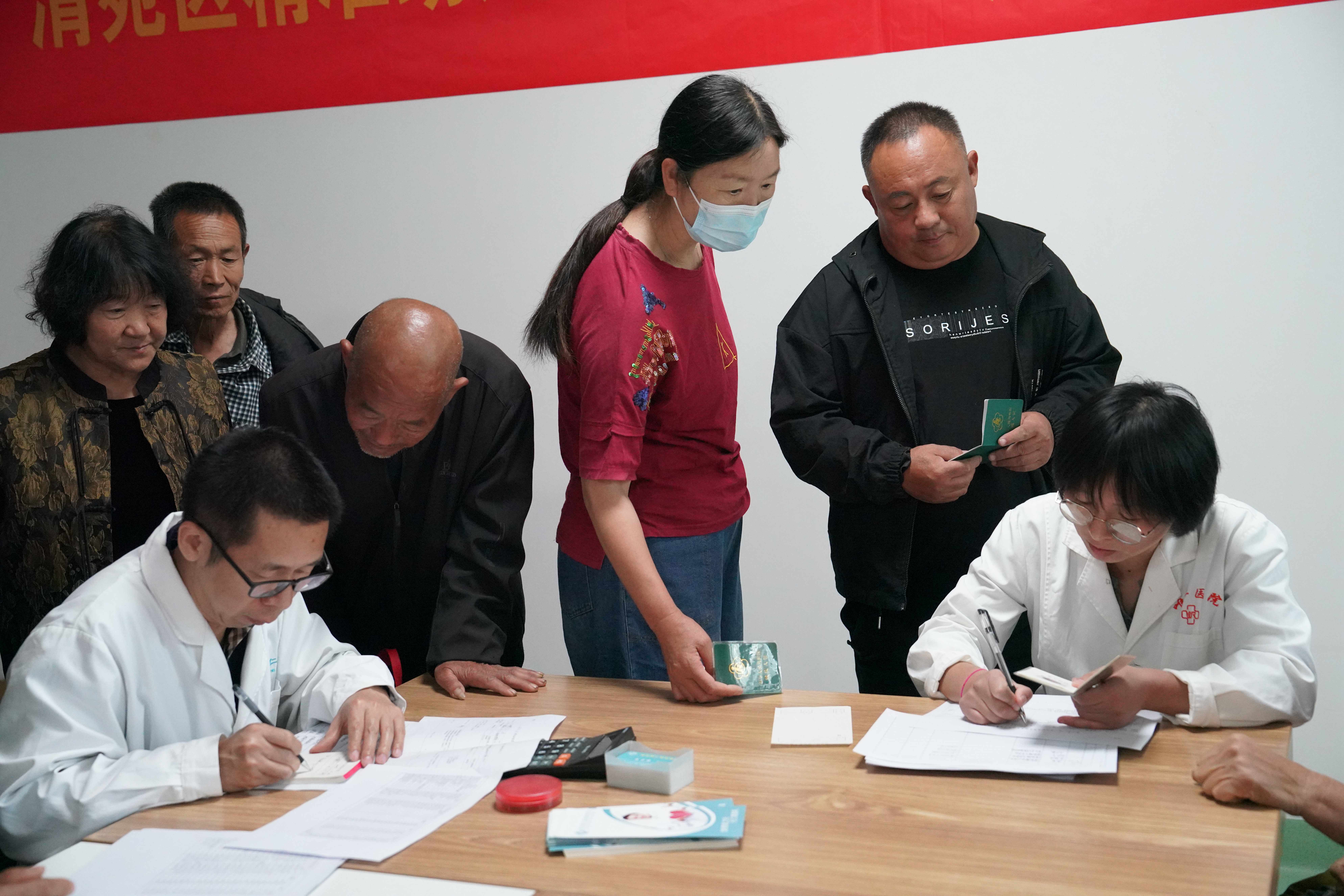 保定清苑：精准助残 免费发药暖民心_fororder_医生询问精神障碍患者家属患者病情，为患者开处方。摄影 王磊