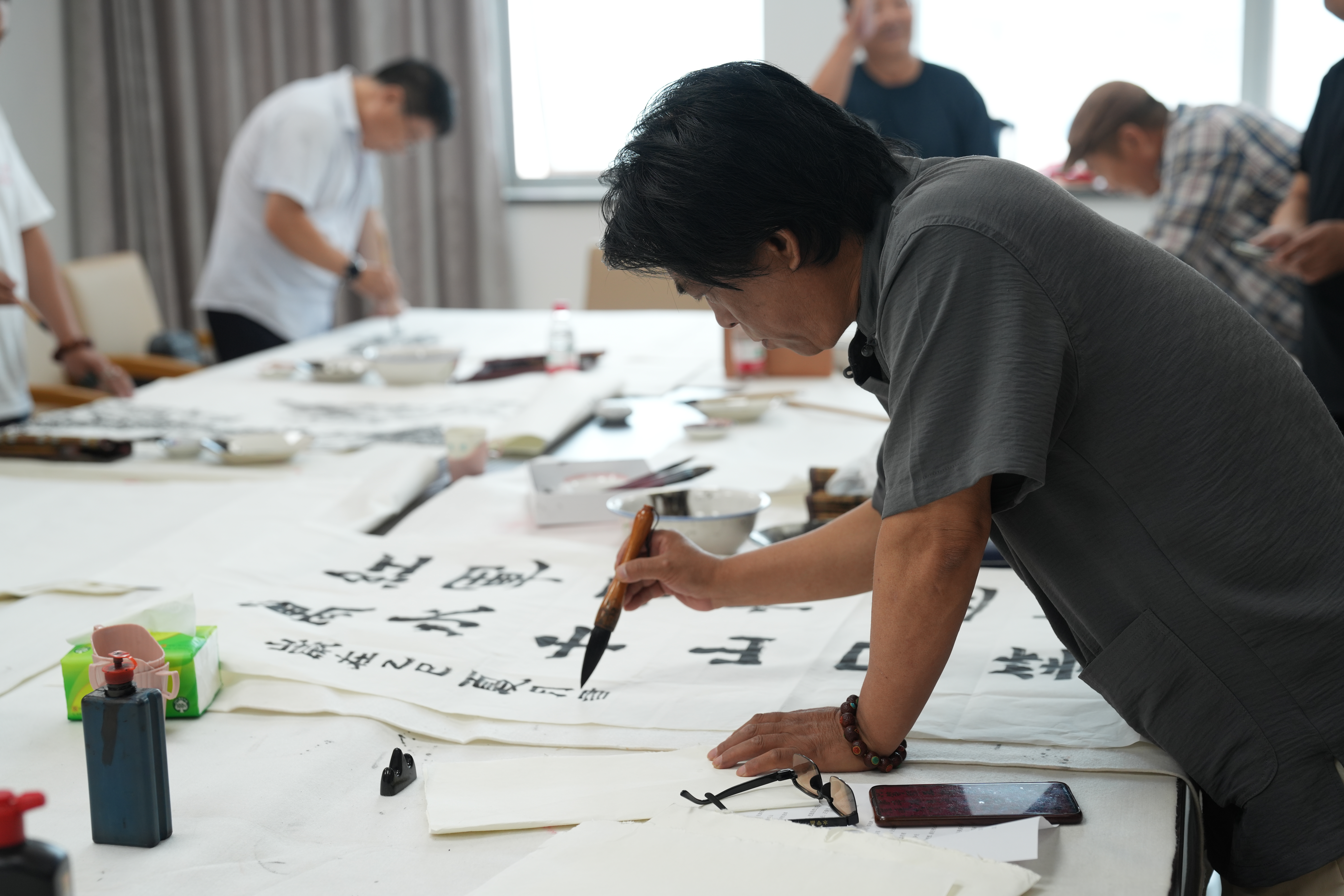 河北迁安：墨染百年峥嵘 笔书向党红心_fororder_6月30日，迁安市书画爱好者正在创作书法作品《七律·长征》（节选）。张泽慧摄.JPG