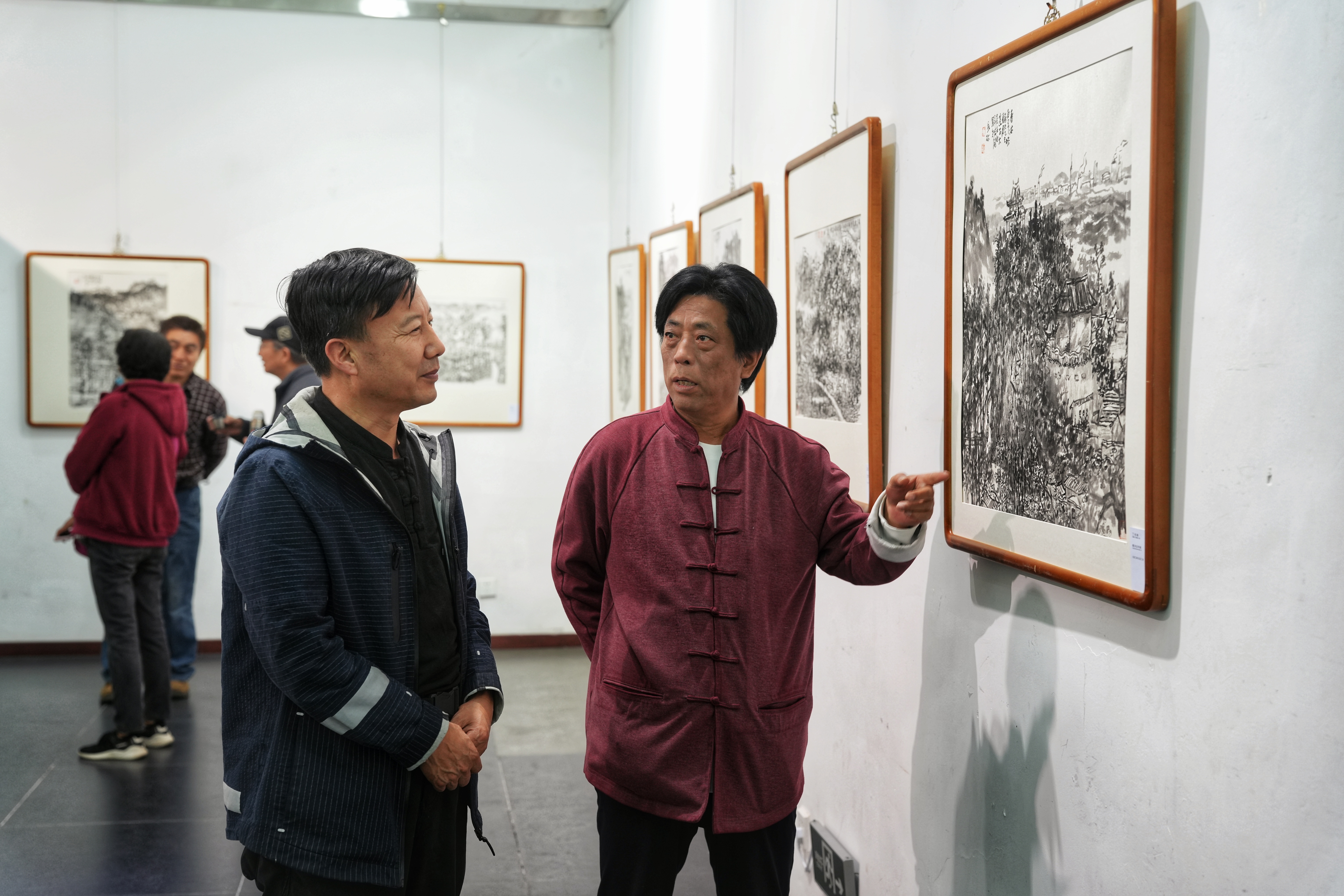 河北省迁安市“纸映长城韵 墨染迁安情”—“迁纸画迁安”水墨长城乡韵主题展开幕_fororder_5月9日，参展书画家正在为市民讲解画作。张泽慧摄