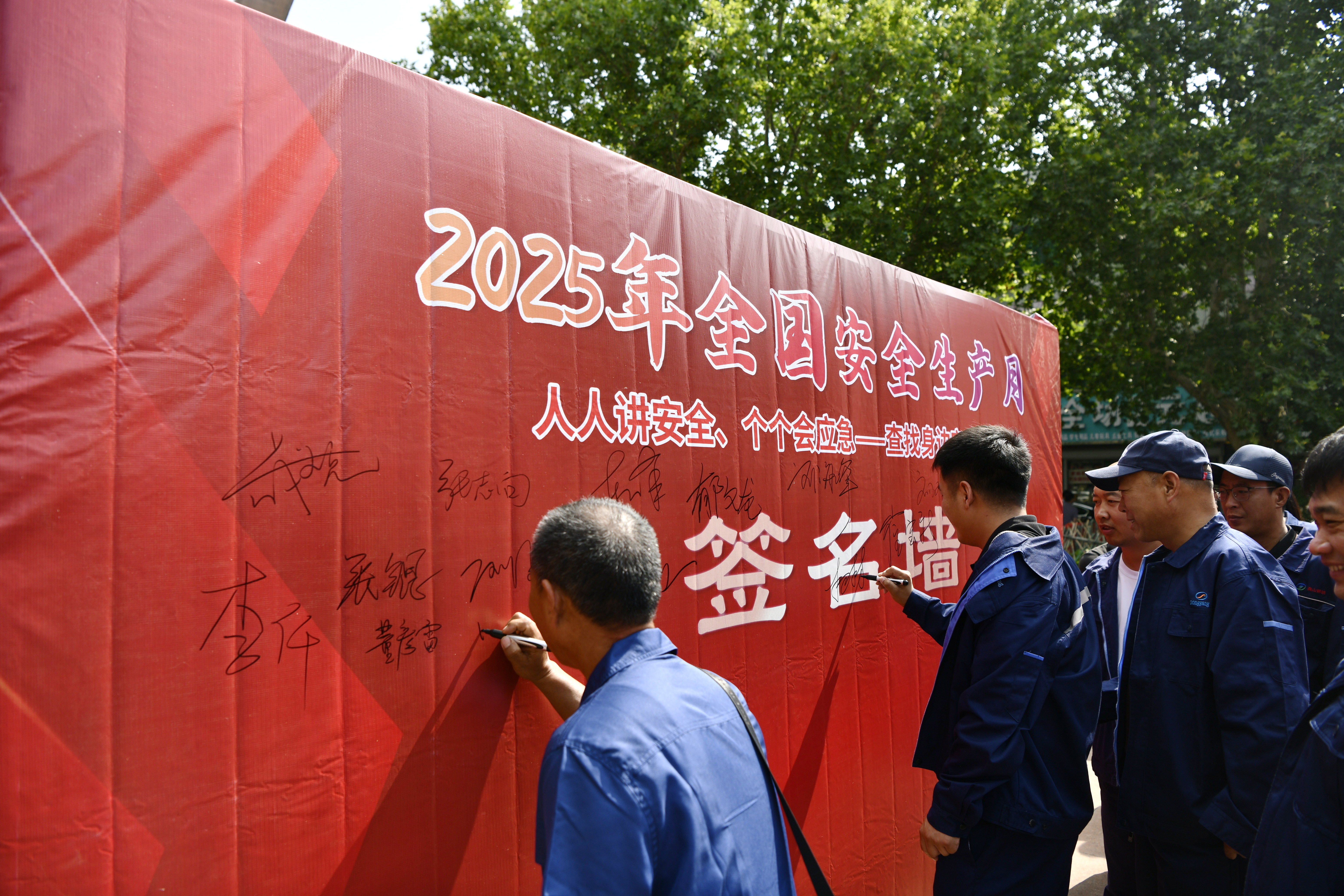 迁安市开展“安全生产月”咨询日活动_fororder_市民在签名墙上签字。梁玉水摄.JPG