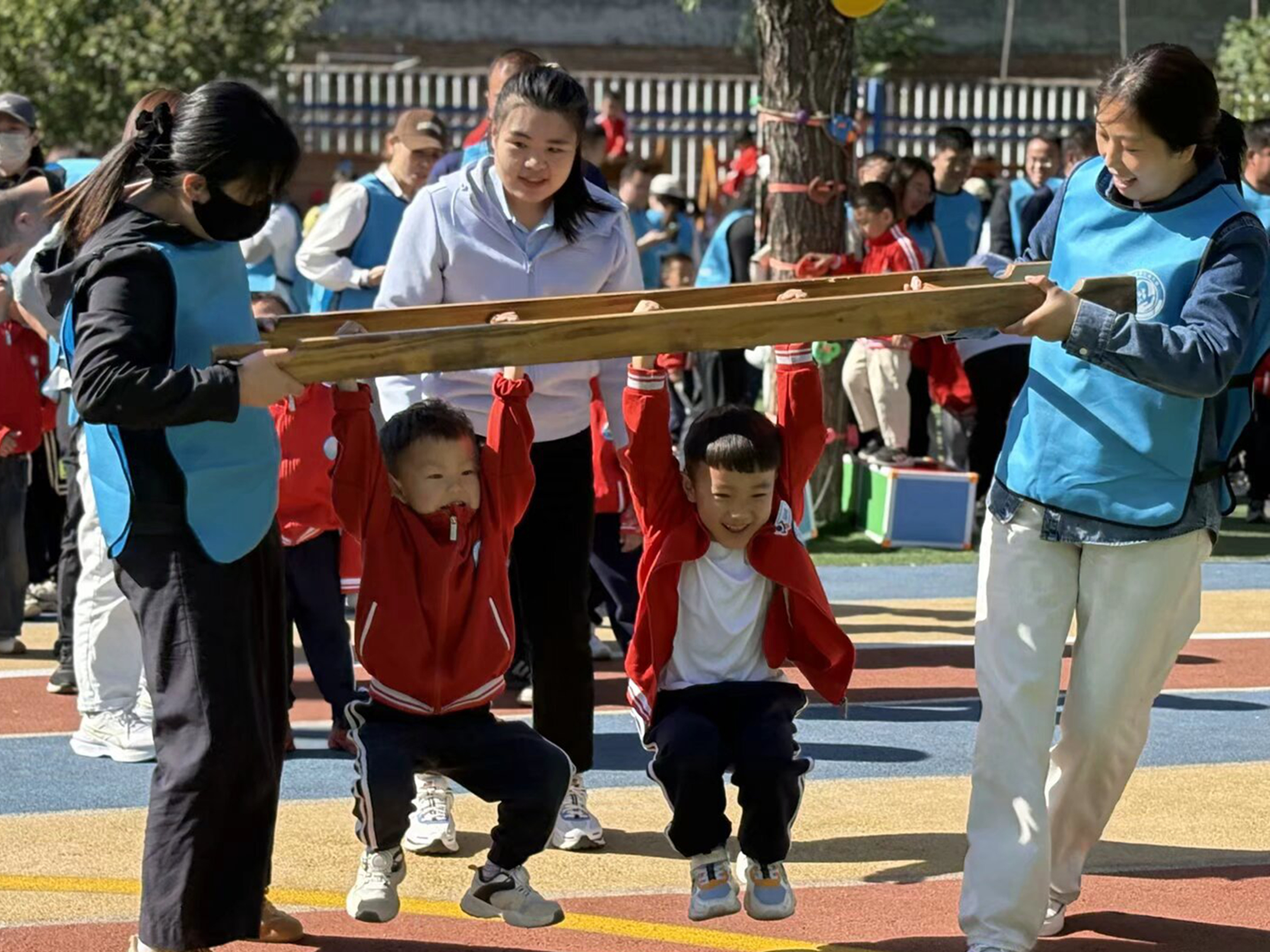 河北唐县：亲子同运动 萌娃乐成长_fororder_亲子互动“梯子运宝贝”项目开展中，家长与孩子默契配合共闯关_看图王
