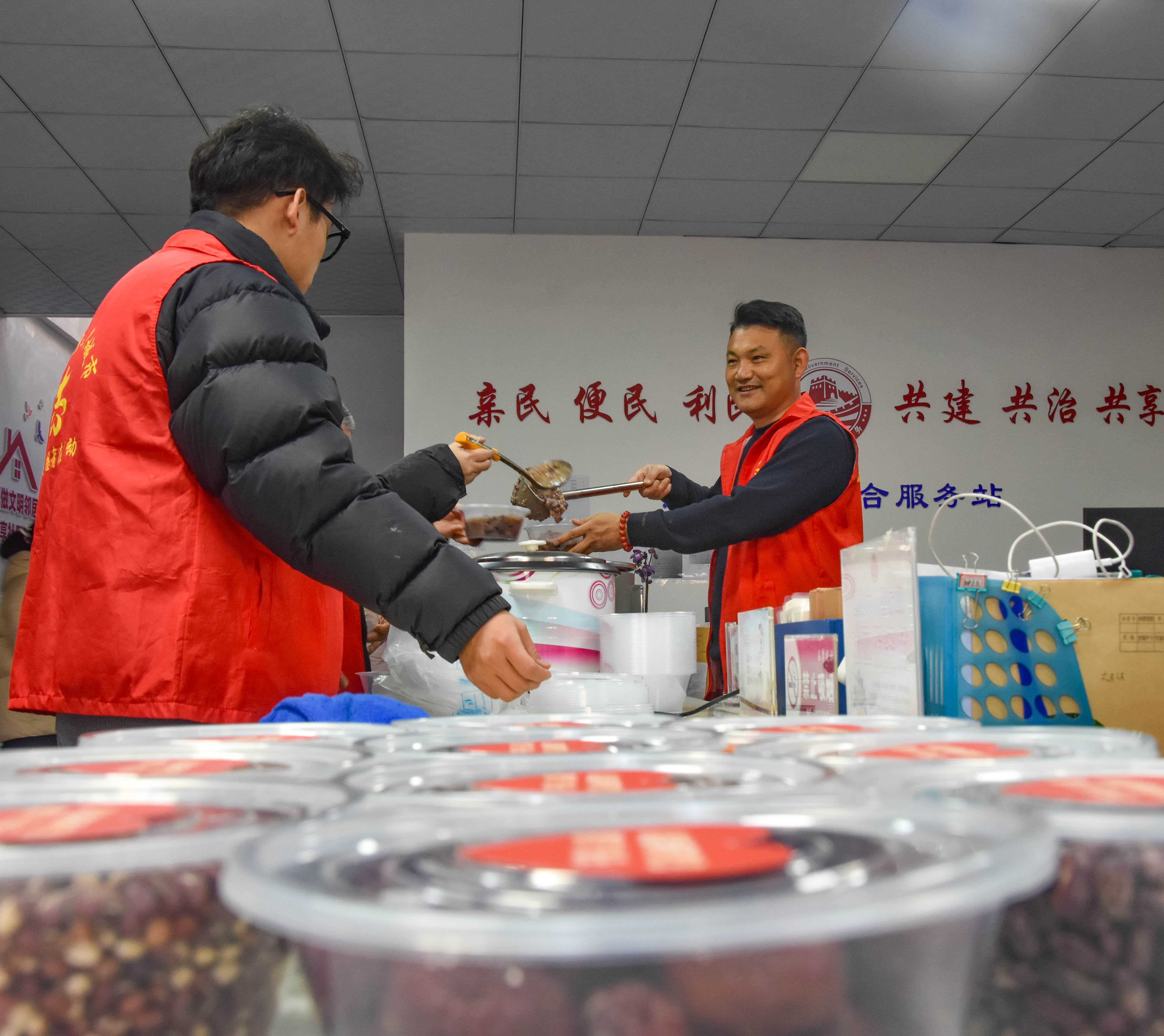 唐山遵化：浓情腊八节 暖心粥飘香_fororder_社区工作者正在将做好腊八粥装进餐盒。许昊 摄