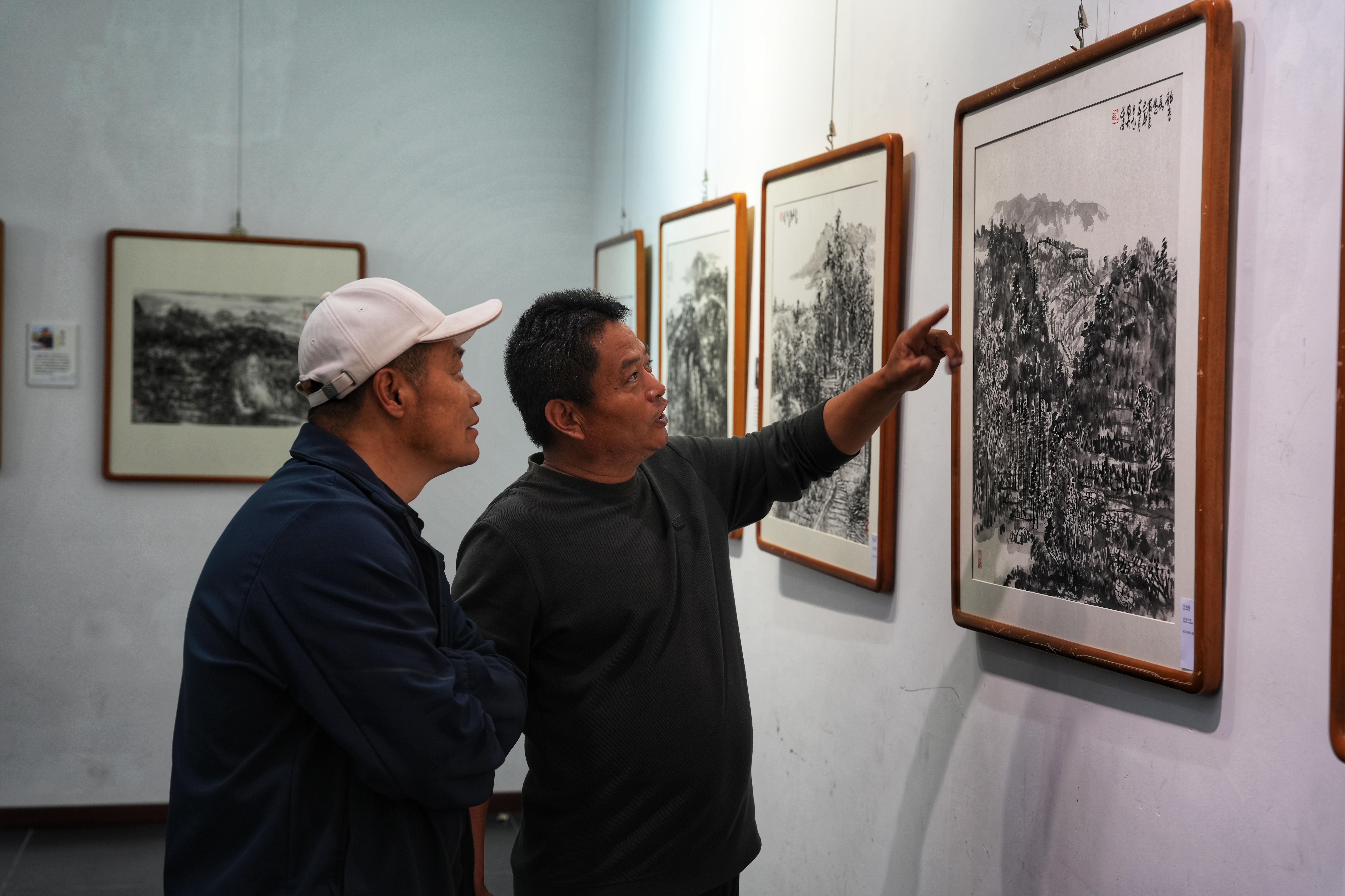 河北省迁安市“纸映长城韵 墨染迁安情”—“迁纸画迁安”水墨长城乡韵主题展开幕_fororder_5月9日，市民正在欣赏参展画作。张泽慧摄
