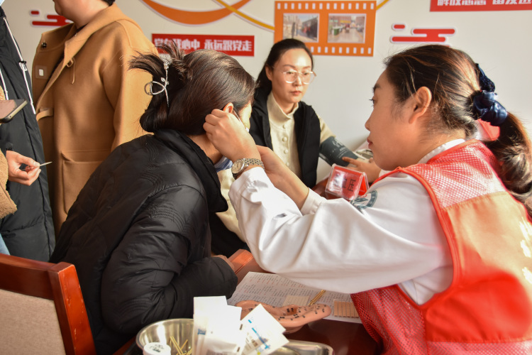 情暖重阳 遵化市开展多彩活动传递敬老温情_fororder_遵化市人民医院医护志愿者正在给群众敷耳贴。许昊 摄