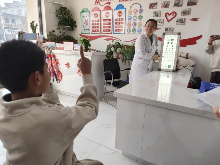 遵化市开展寒假爱心托管班活动_fororder_工作人员正在为孩子检查视力。毛渴鑫摄