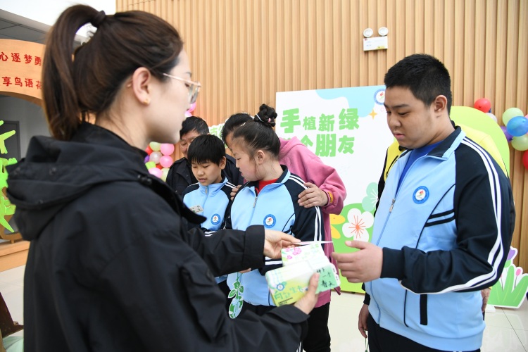 河北承德：绿意萌动 特殊孩子种下希望_fororder_图为承德市特殊教育学校老师正在为启音学生发放种子 张雨樵 摄.JPG
