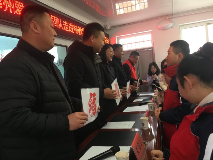 共青团遵化市委开展暖冬捐赠活动 情暖特殊儿童成长路_fororder_学生代表向公益团队送上亲手制作的福字剪纸。徐文杰摄