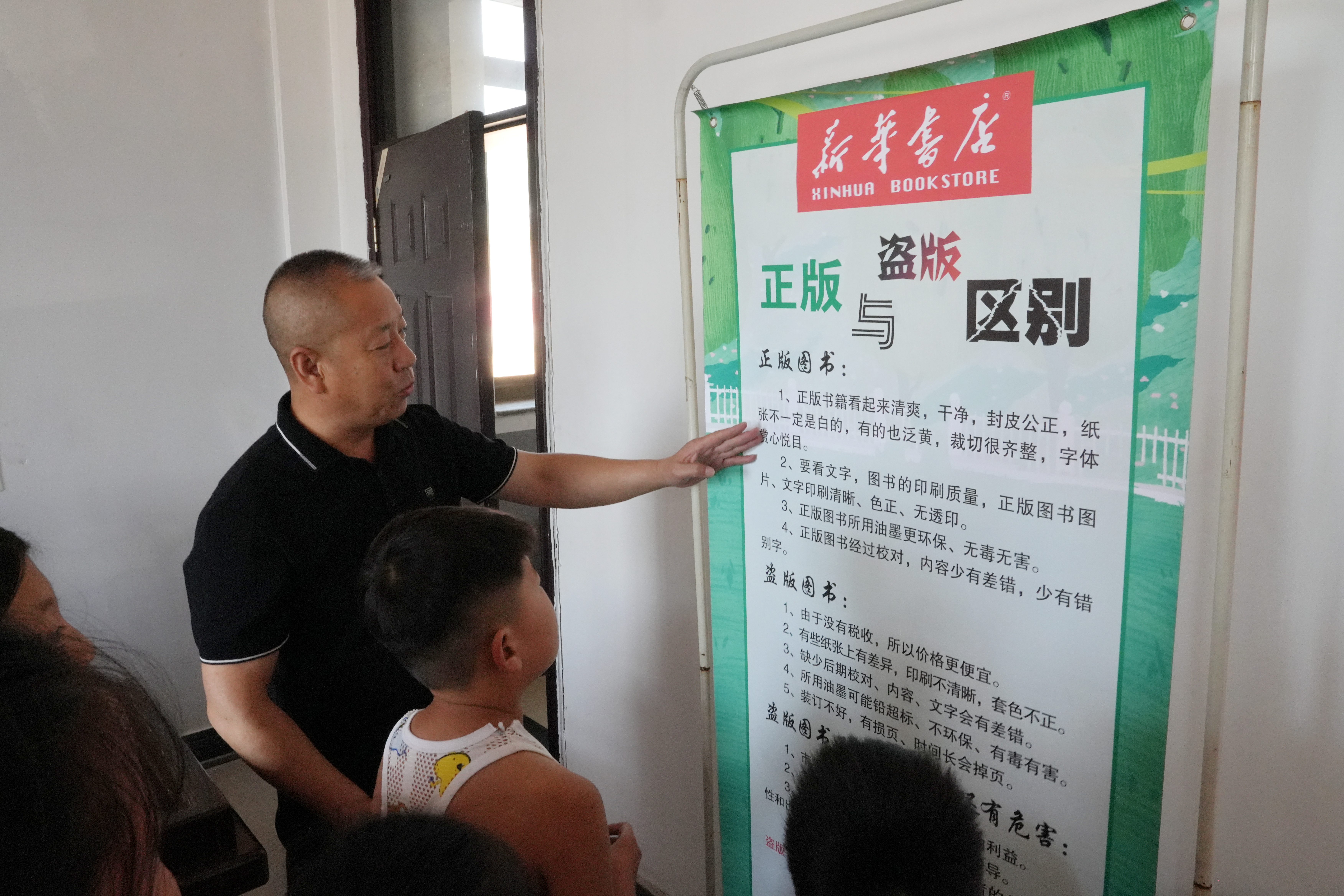 河北迁安：阅读为乡村娃娃带来多彩暑假_fororder_志愿者向孩子们讲述了正版和盗版图书区别。梁玉水摄.JPG