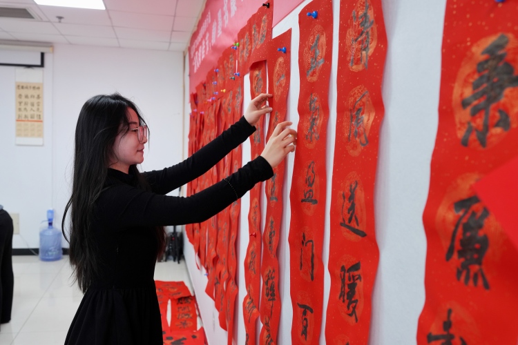 河北迁安：清风润佳节 翰墨书廉心_fororder_1月28日，书法爱好者正在把写好的春联贴在墙上晒干。张泽慧摄