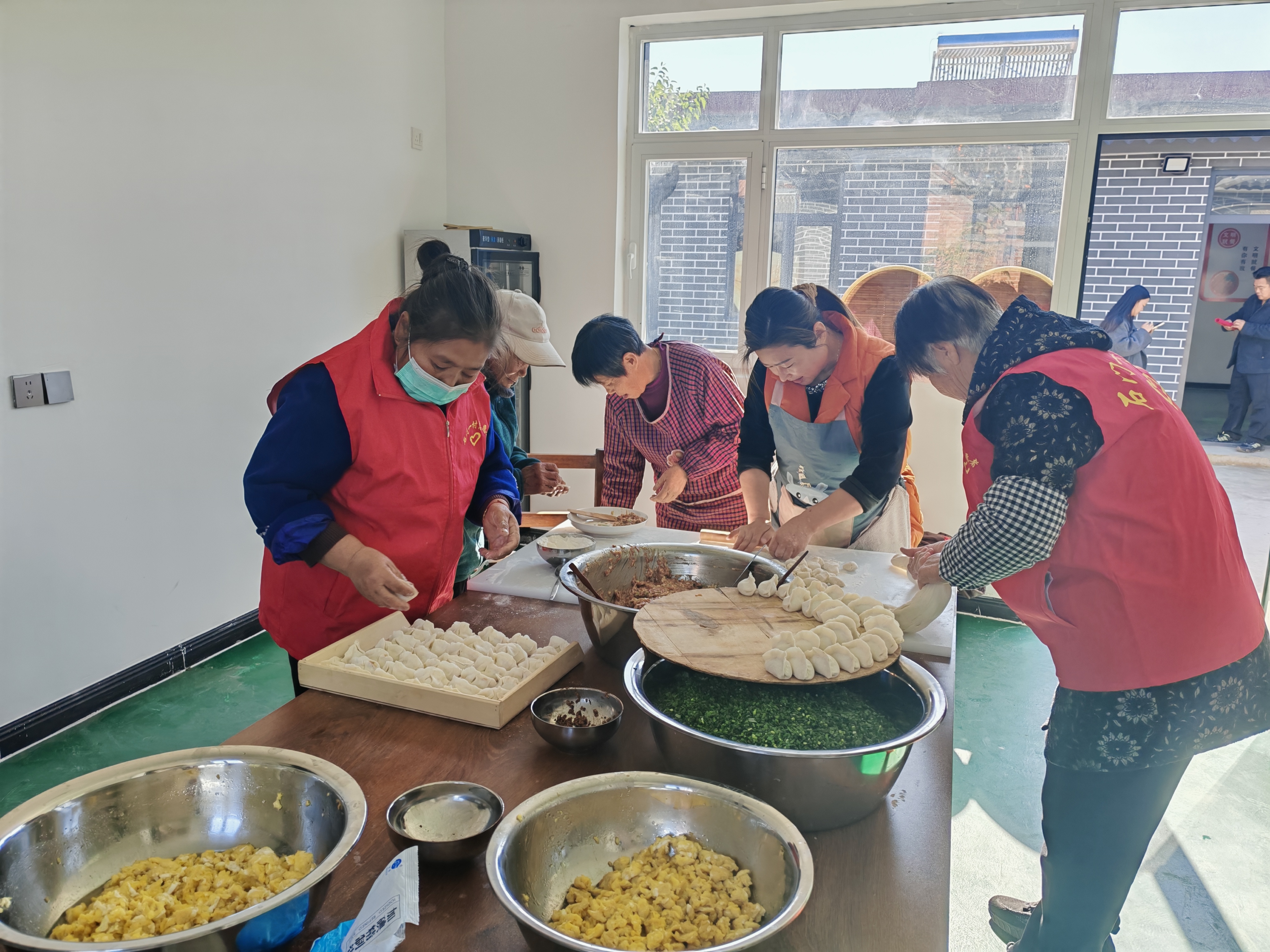 情暖重阳 遵化市开展多彩活动传递敬老温情_fororder_遵化市石门镇石门一村组织志愿者为老人包饺子。 翟雪梅摄