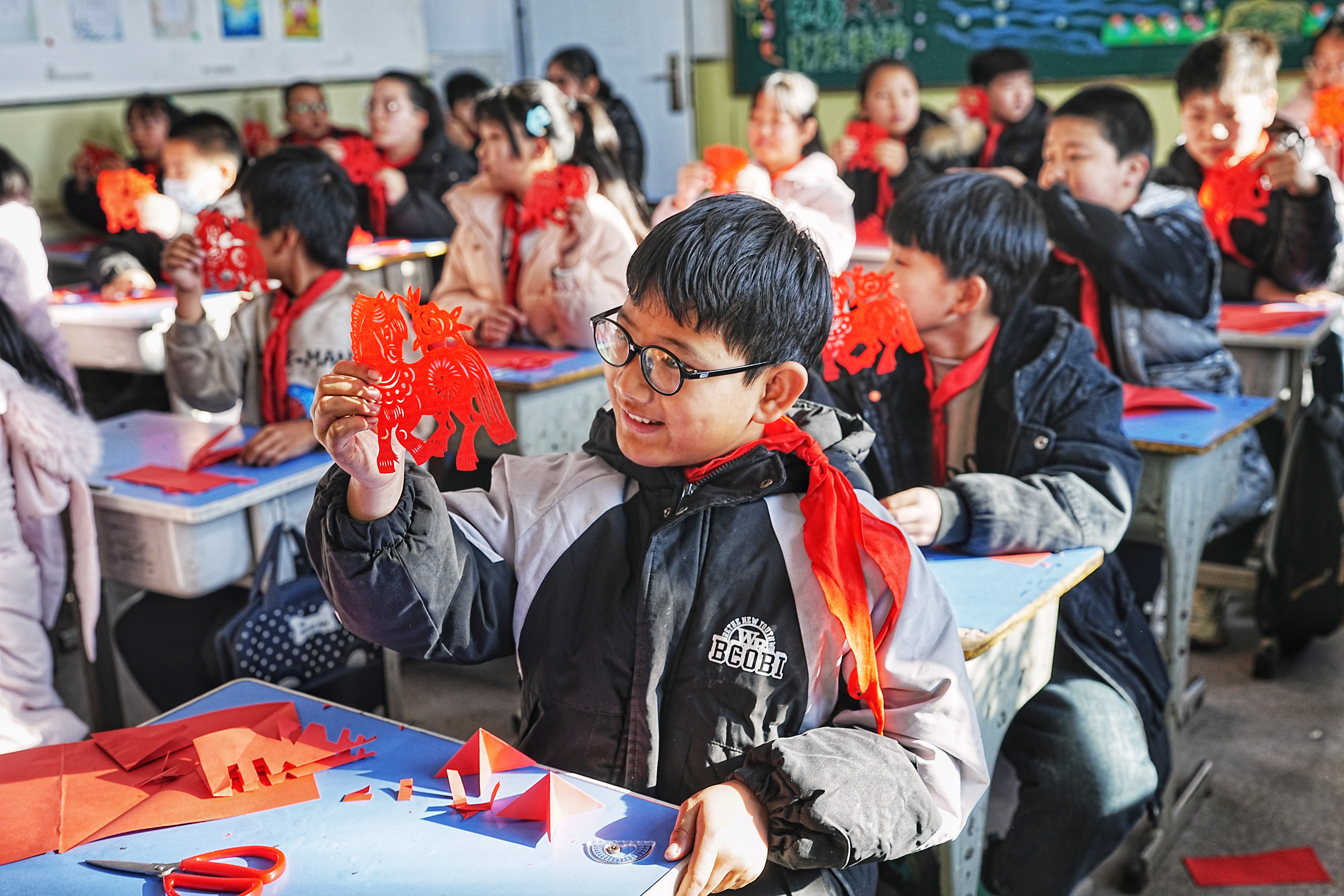 河北迁安：剪纸非遗进校园 指尖生花迎新年_fororder_12月25日，学生们正在欣赏自己亲手剪出来的剪纸作品。张泽慧摄