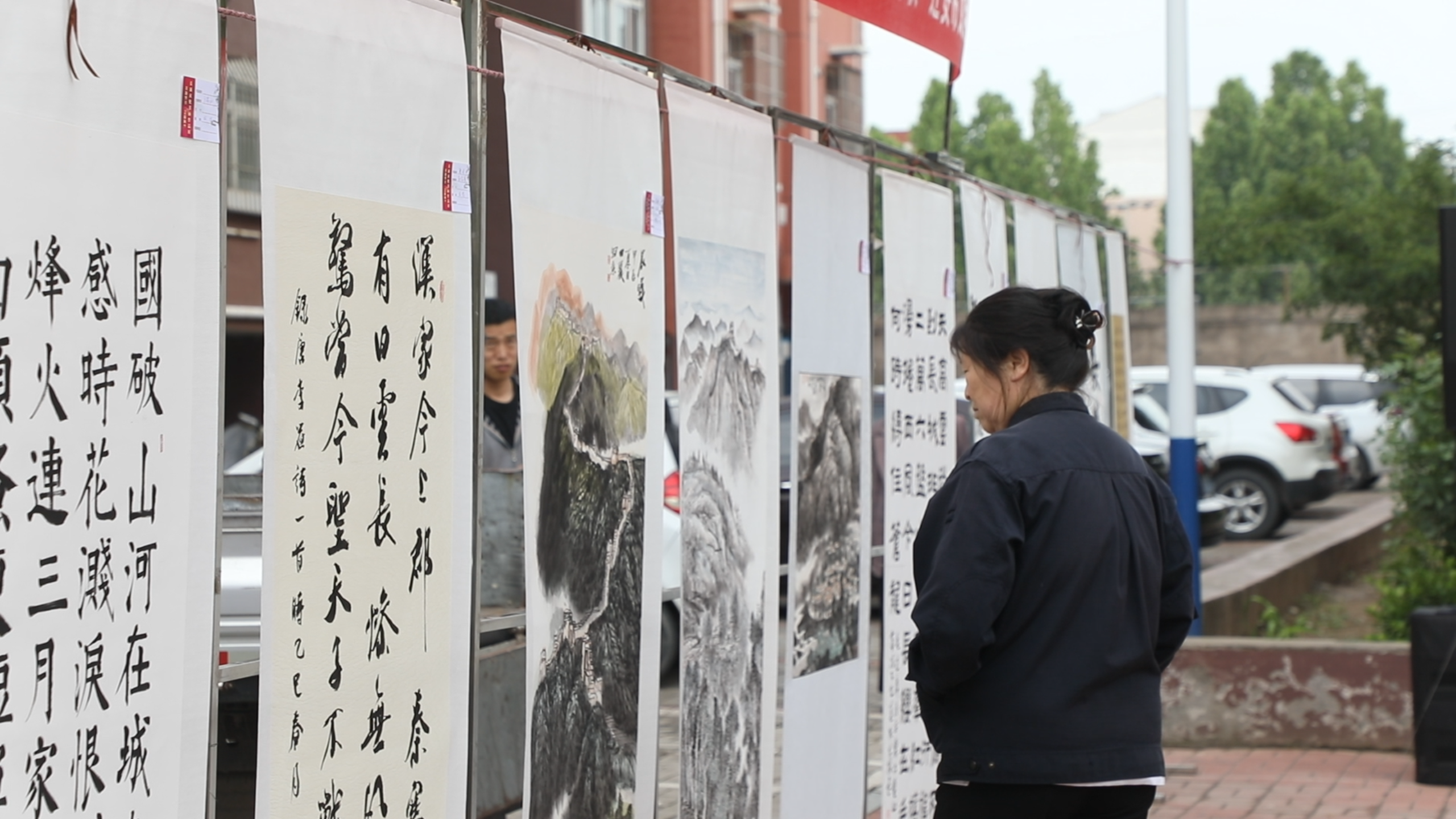 河北迁安：文艺志愿服务进社区暖民心_fororder_5月23日，迁安市常青社区居民正在参观“长城文化主题书画巡展”。王志斌摄