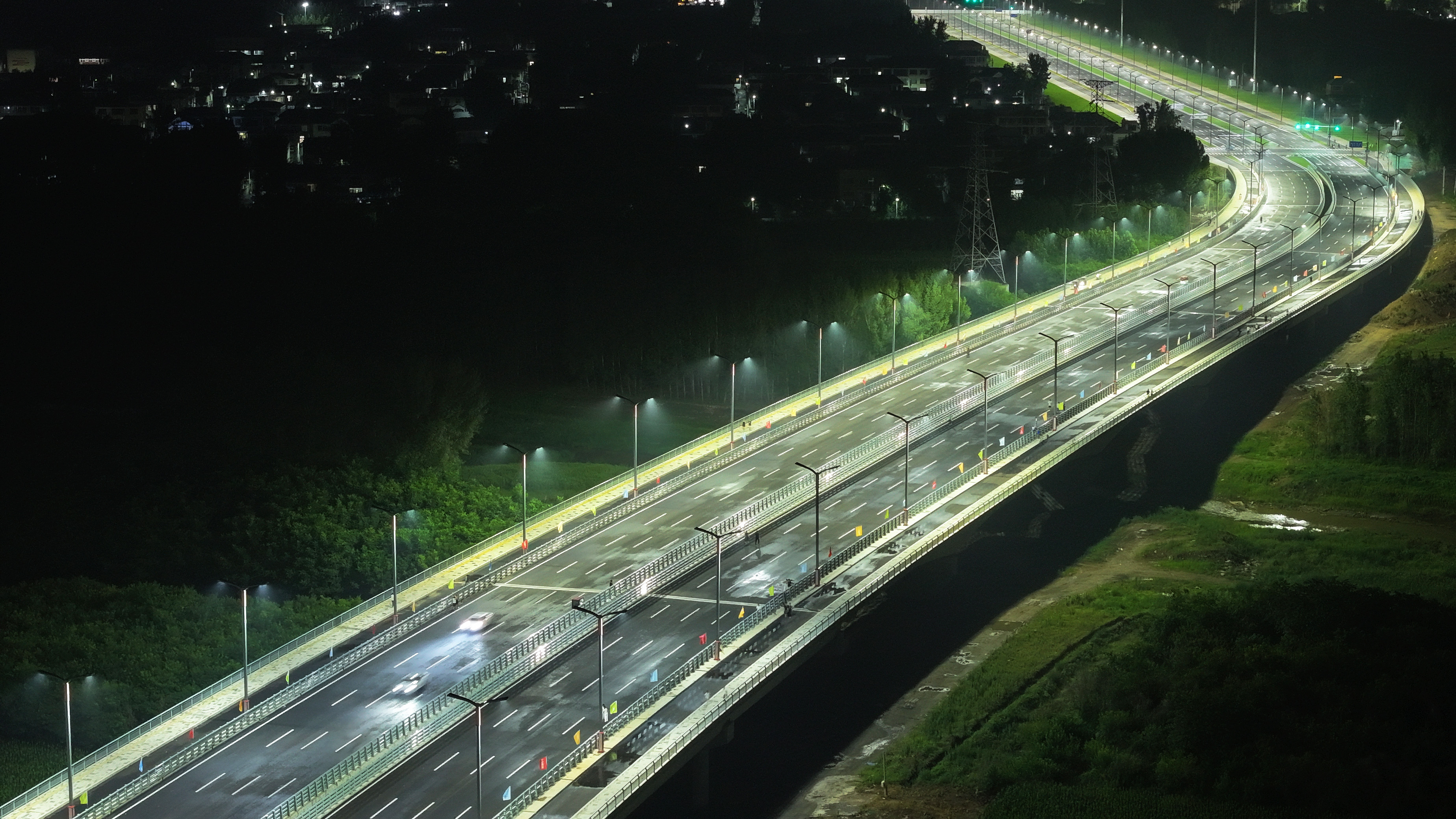 河北涿州：腾飞大街北延跨北拒马河大桥建成通车_fororder_7月1日，河北省涿州市腾飞大街北延跨拒马河大桥正式通车。图为6月30日晚，车辆在大桥上试行（航拍照片）。熊华明摄