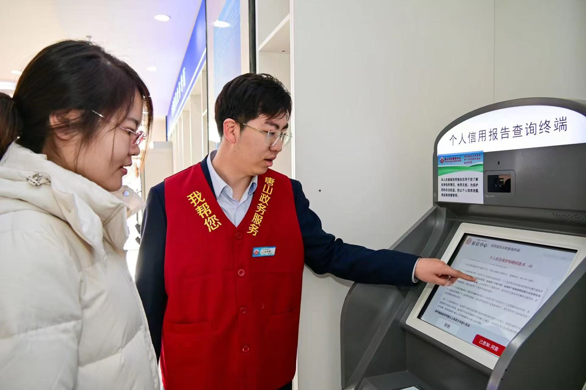 唐山召开《唐山市优化营商环境若干规定》 实施新闻发布会_fororder_2024年12月17日，唐山市政务服务中心工作人员正在指导办事群众查询打印个人信用报告