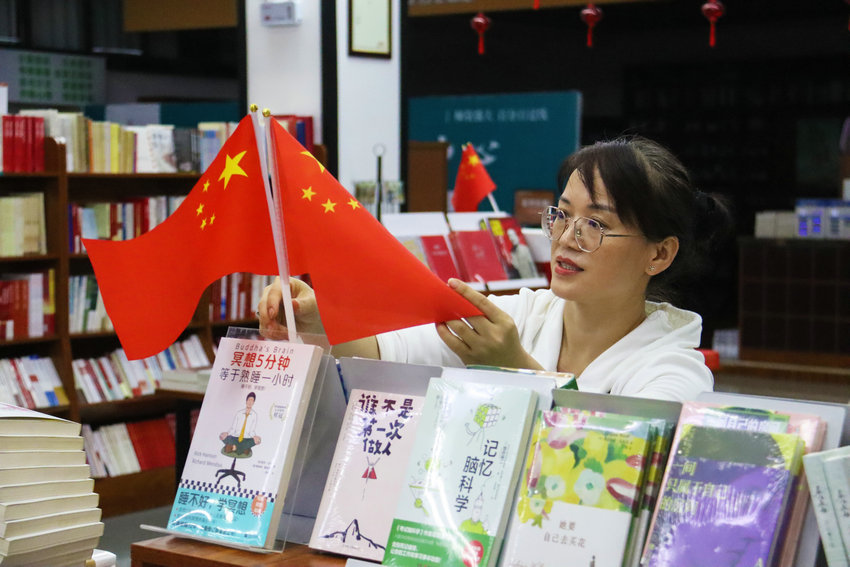 南阳市卧龙区：国庆中秋节日氛围浓_fororder_书店工作人员在摆放国旗 摄影 王小军.JPG